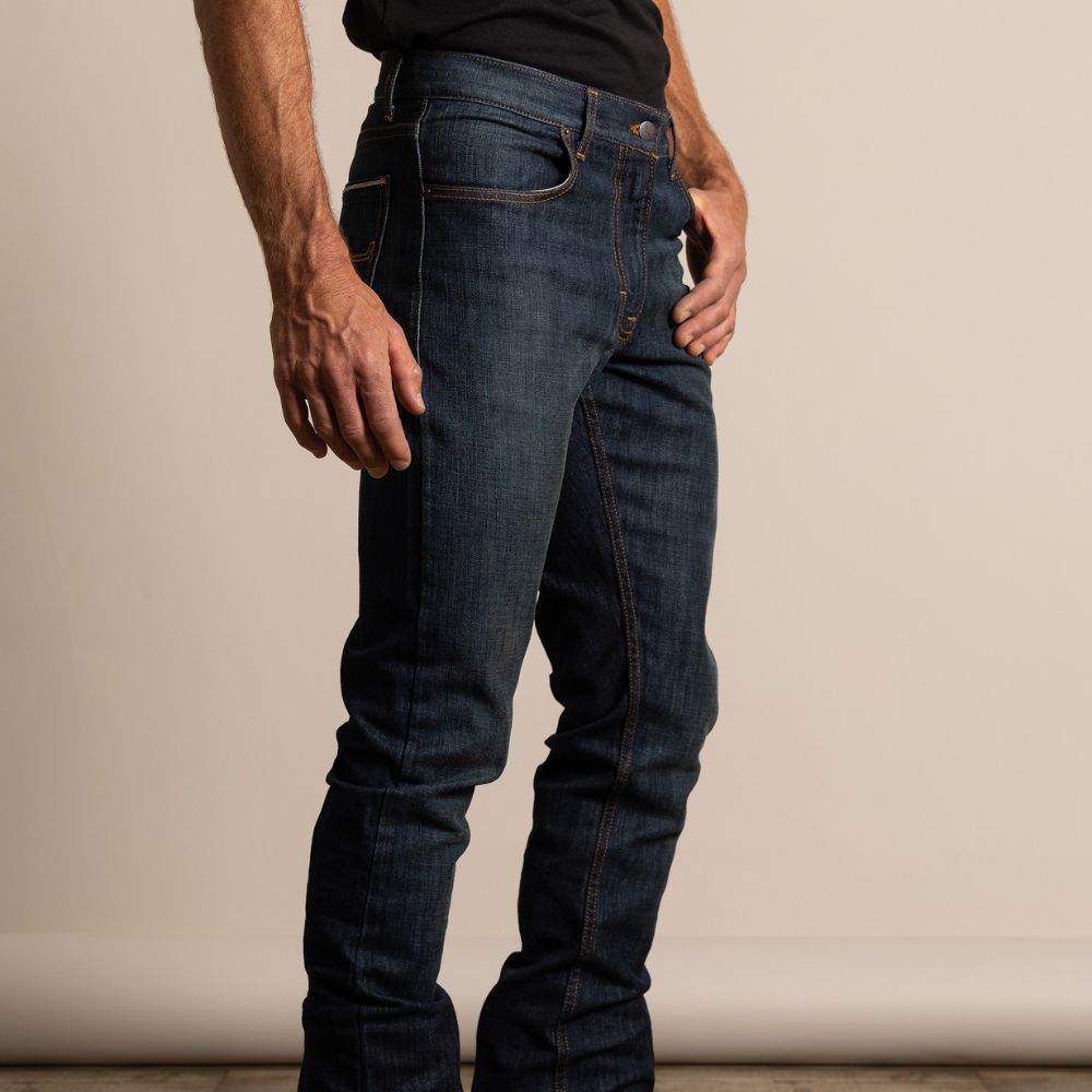 Man wearing Kimes Ranch Roger jeans in a dark wash with a mid-rise and straight-leg fit. The jeans feature clean stitching, a tailored look, and a versatile Western style made for everyday wear.