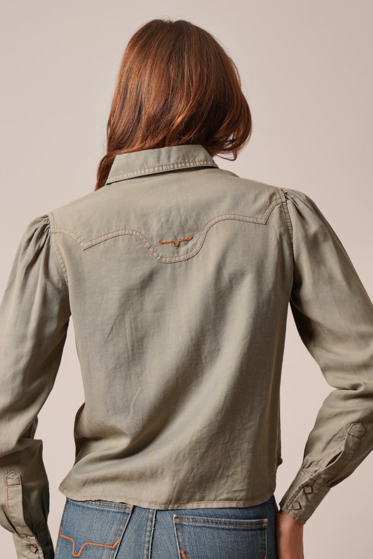 Kimes Ranch Cece top in Moss, showing the back yoke with the Kimes Ranch logo, long sleeves, and contrast stitching