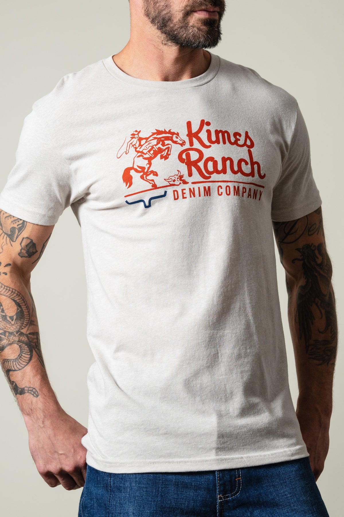 Kimes Ranch Davona Dale short sleeve sand t-shirt with red Kimes Ranch logo and blue longhorn graphic on chest; #color_sand