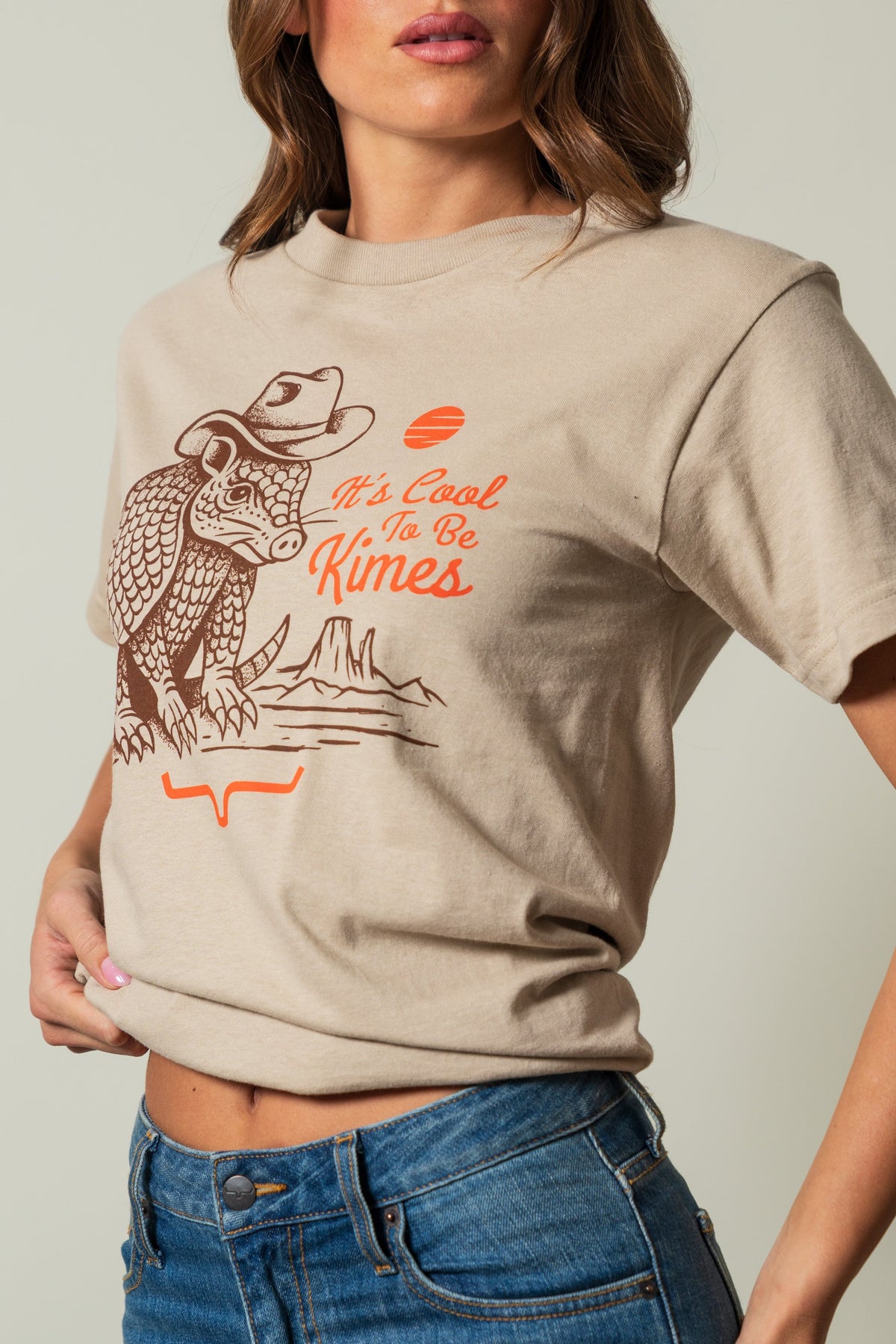 Kimes Ranch Dillo shirt in Sand, featuring a long-sleeve tee with a graphic of an armadillo wearing a cowboy hat and the text; #color_sand