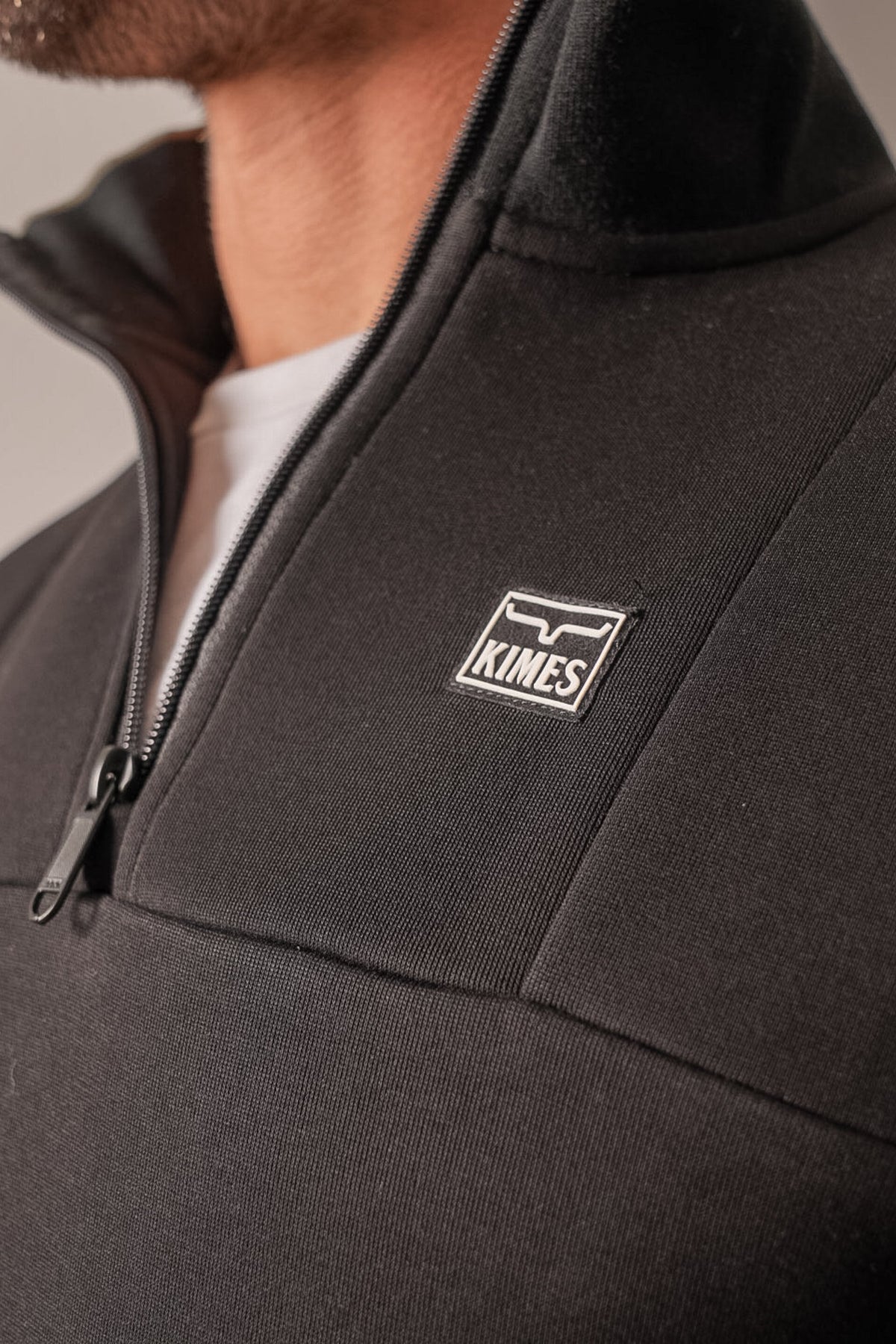 Kimes Ranch Doncast sweatshirt in black, detail of the chest Kimes Ranch logo and half zip