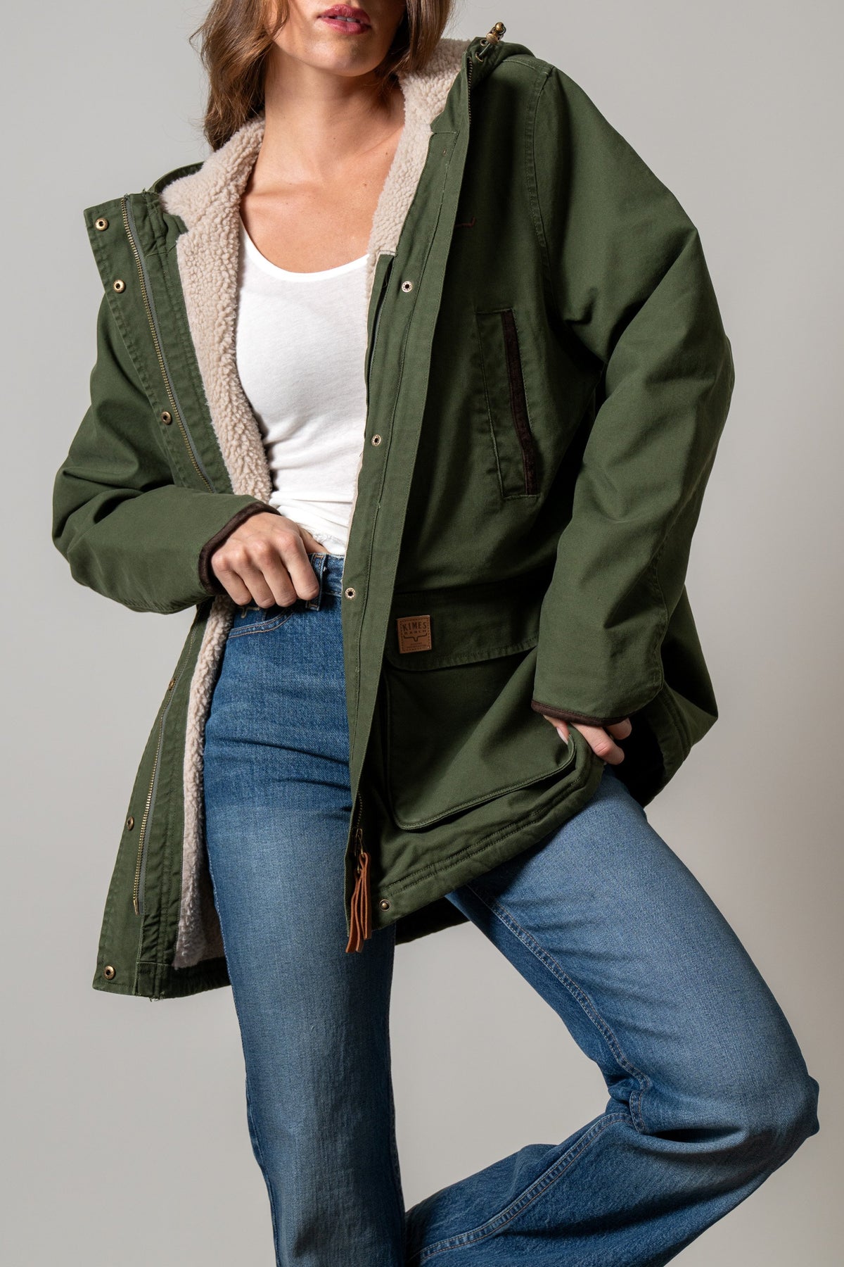 Kimes Ranch Emery jacket in Moss with a hood, cream sherpa lining, snap buttons, zippered chest pocket, and logo patch