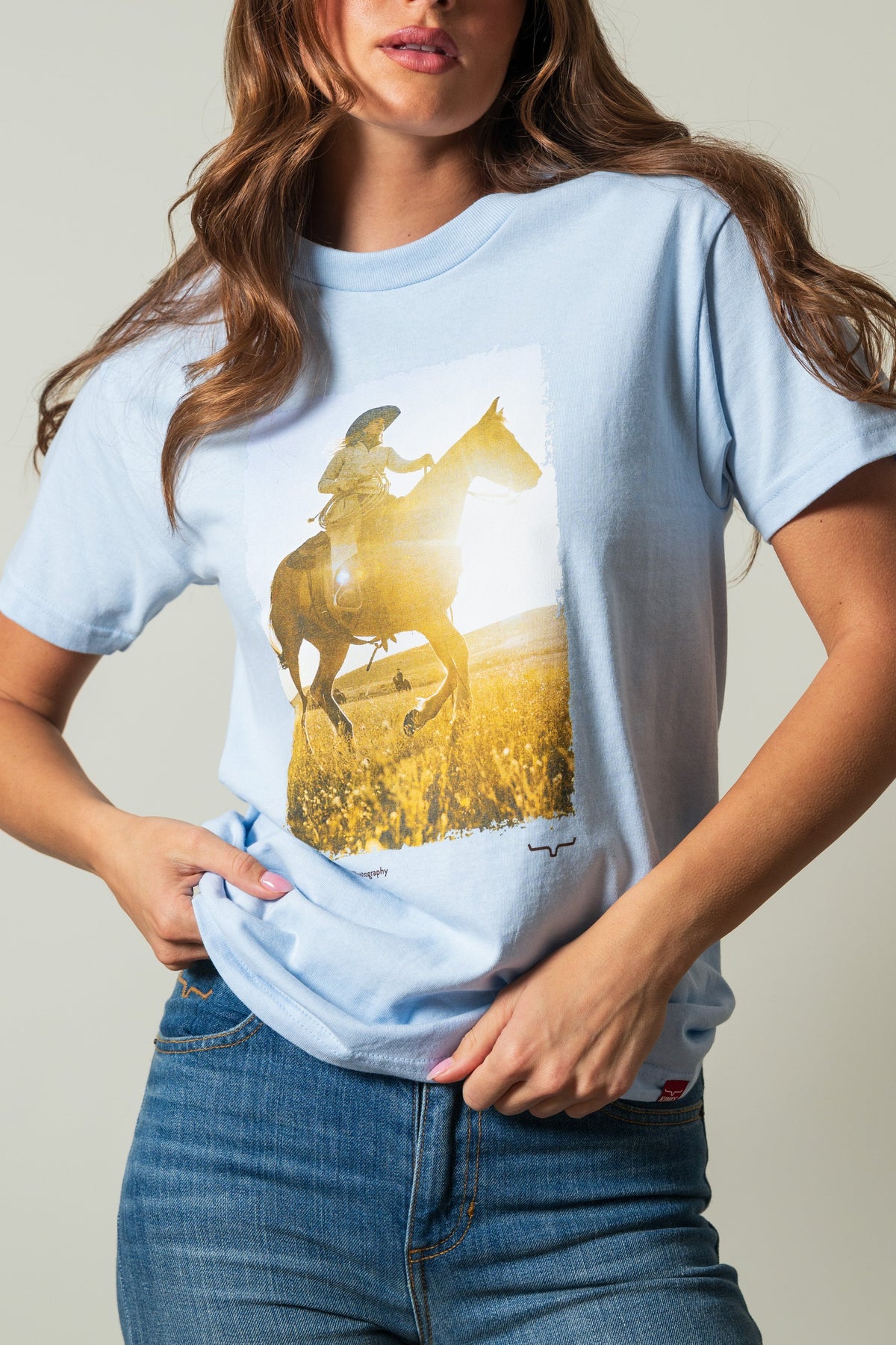 Kimes Ranch SS Riding Sunshine powder blue shirt with a graphic of a rider on a horse in a sunny field; #color_powder blue
