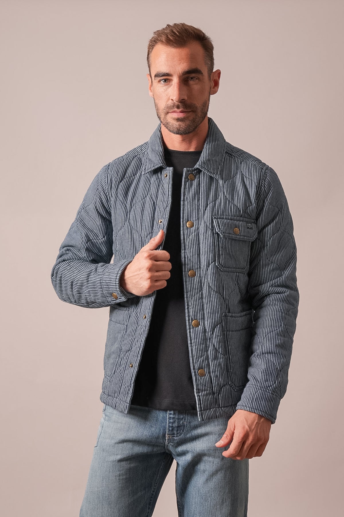 Kimes Ranch Buster indigo quilted jacket with long sleeves, chest pocket, front button closure, and collar, worn by a man