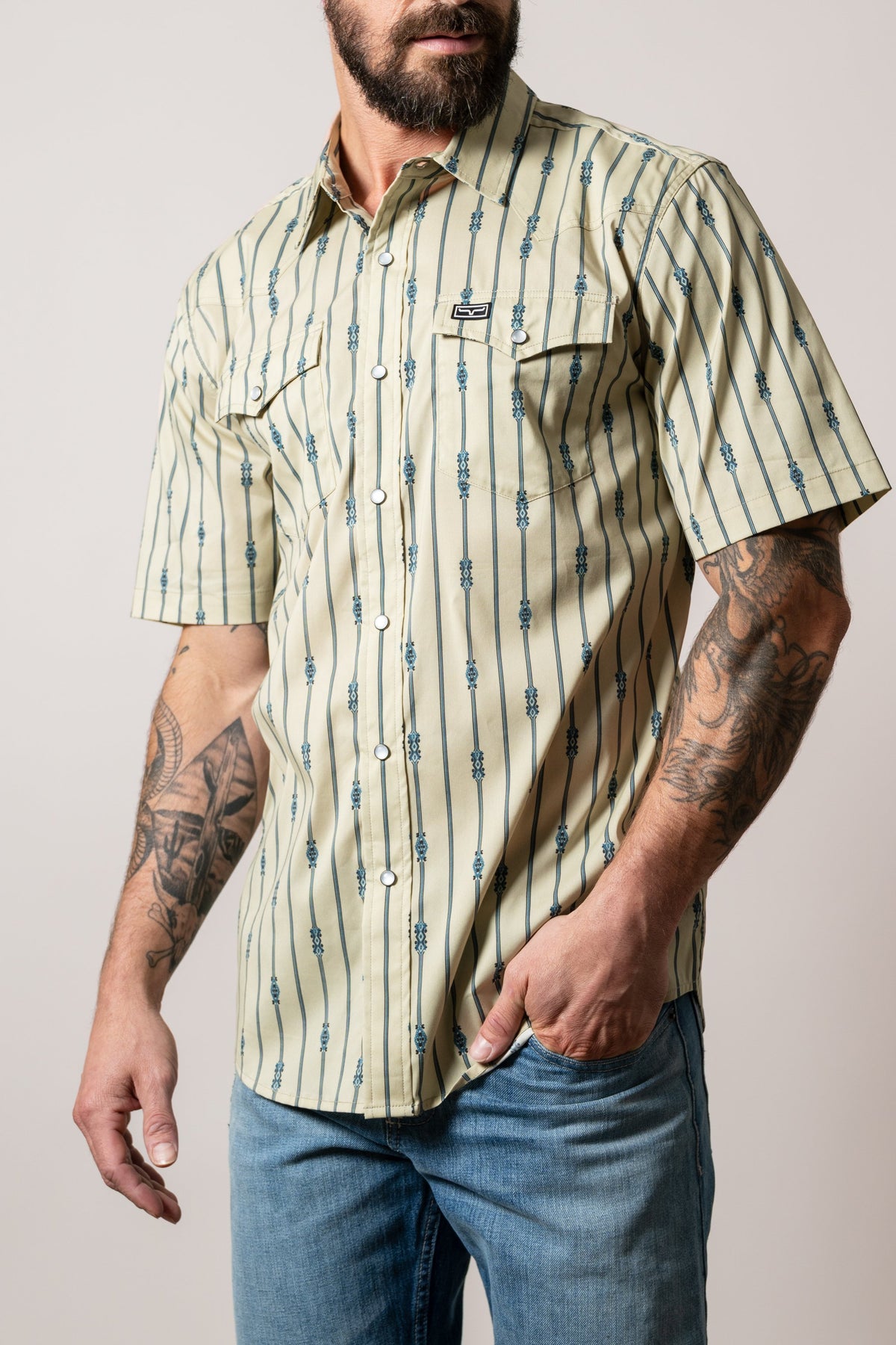 Kimes Ranch Gunner khaki short sleeve dress shirt with blue vertical stripe print, snap button closure