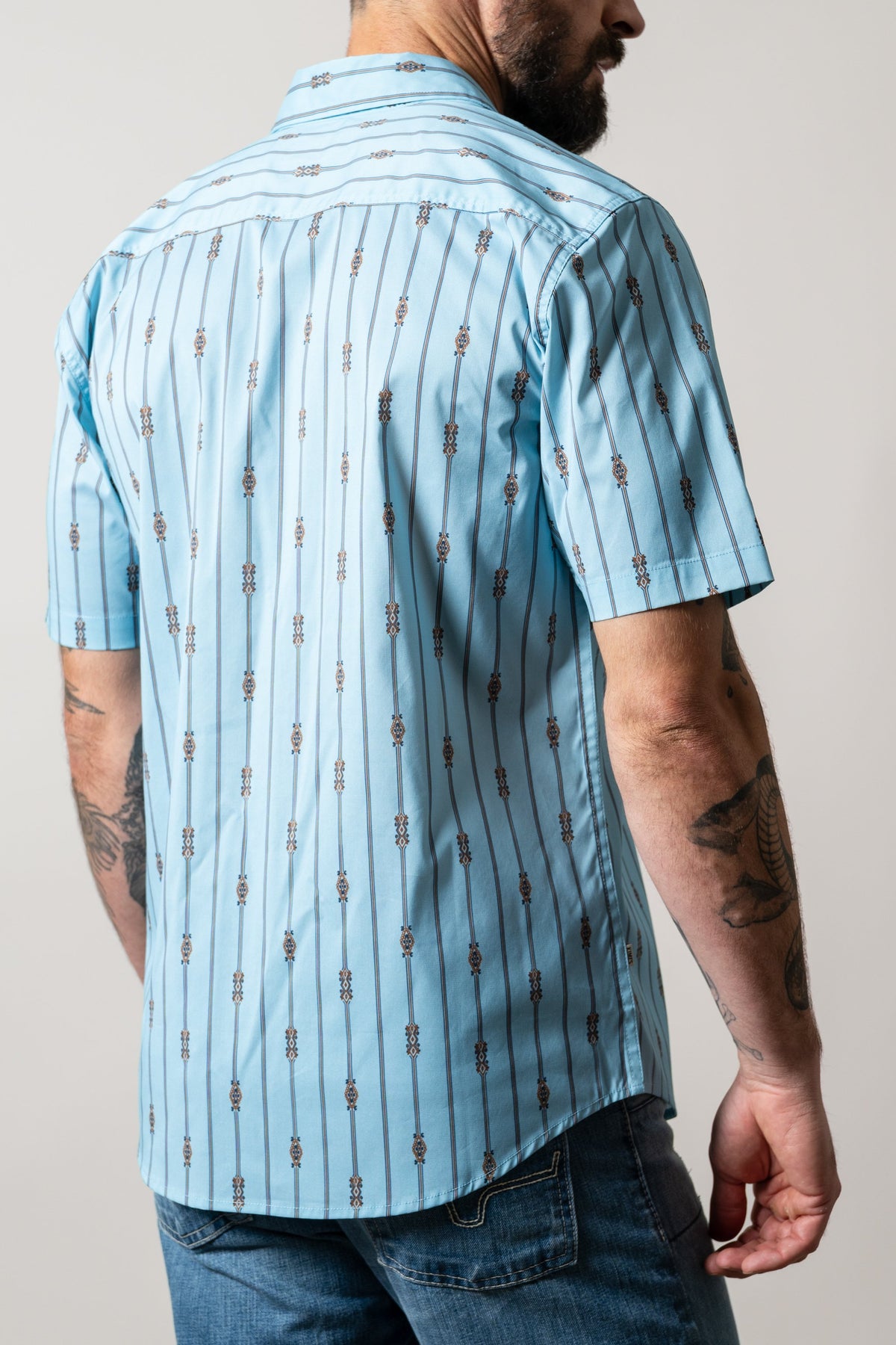 Kimes Ranch Gunner short sleeve dress shirt in light blue with vertical stripes and motifs on the back
