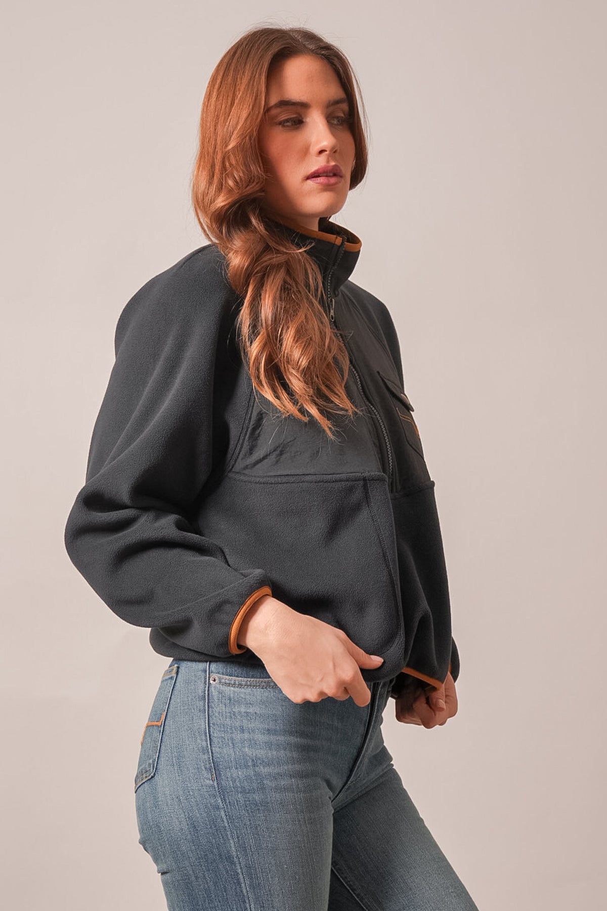 Kimes Ranch Indie sweatshirt in black, featuring a high collar with brown trim, zippered chest pockets, and ribbed cuffs