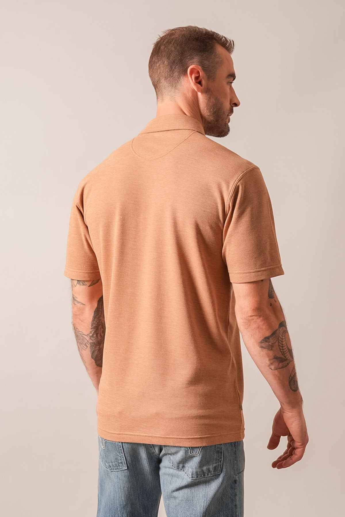 Kimes Ranch Kingsley men's short-sleeve polo shirt, Brown Heather, showing the back yoke and fit on a model