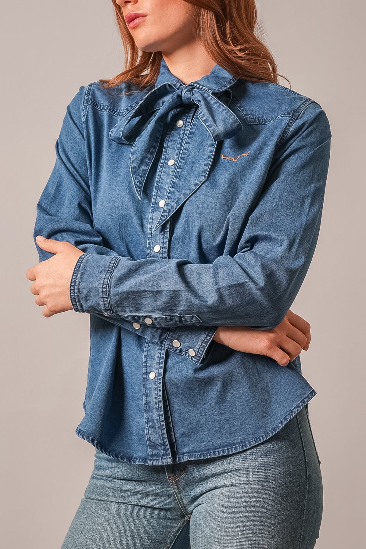 Kimes Ranch Lolo indigo long sleeve denim button up top with bow tie neck and Kimes Ranch logo embroidery on chest