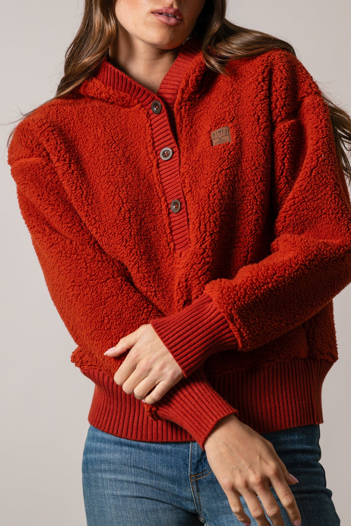Kimes Ranch Shayla hoodie in Burnt Red, featuring a hood, three-button placket, ribbed cuffs, and Kimes Ranch logo patch