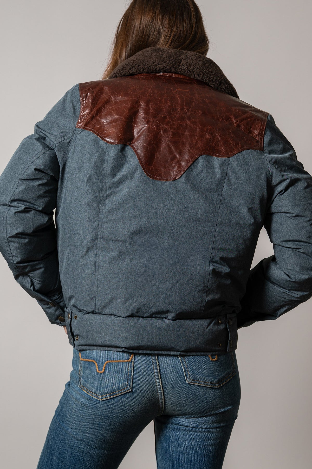 Kimes Ranch Sierra jacket back view, black with brown leather yoke, shearling collar, adjustable waist tabs, and long sleeves