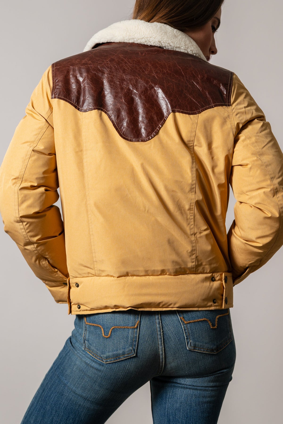 Back view of Kimes Ranch Sierra jacket in Coffee with brown leather yoke, white sherpa collar and snap hem