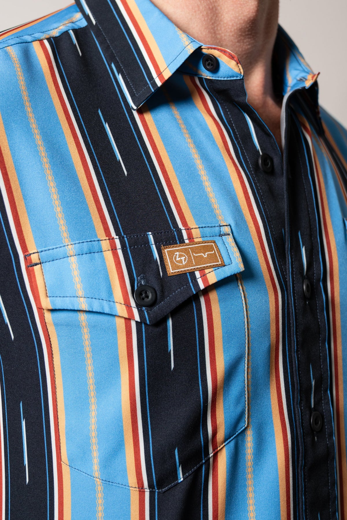 Kimes Ranch ZT Hickory dress shirt in Mid Blue with multicolor vertical stripes, front chest pocket, and leather logo patch