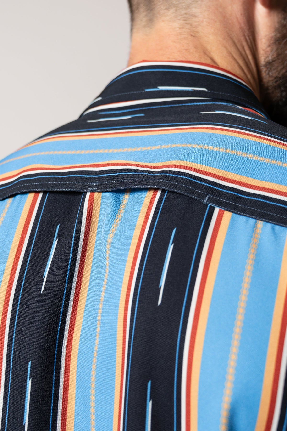 Kimes Ranch ZT Hickory Mid Blue men's dress shirt, back view with bold vertical stripes in navy, rust, cream and light blue